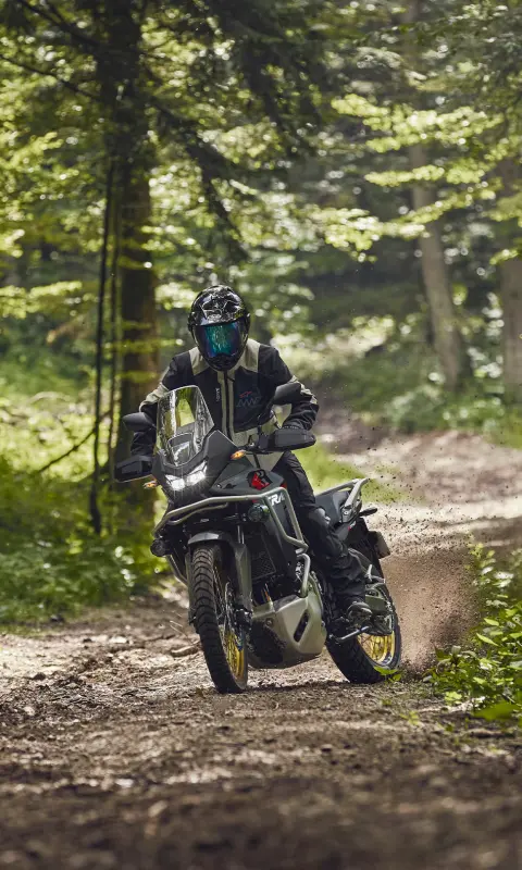 Figurant jedoucí na motocyklu XL750 Transalp v lese